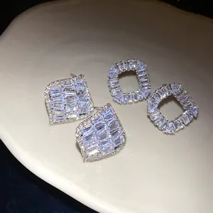 Gros plan de boucles d'oreilles clous en zircon étincelant, carrées et évidées