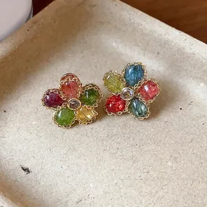 Vintage colorful flower stud earrings with sparkling zirconia set on a textured beige tray