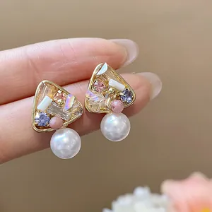 Close-up of elegant 18k gold plated stud earrings with crystals and pearls