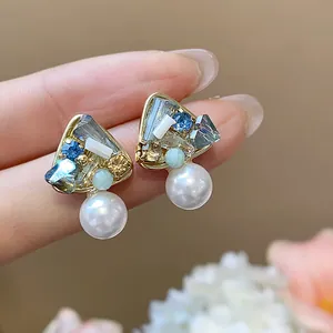 Close-up of elegant 18k gold plated geometric earrings with crystals and pearls