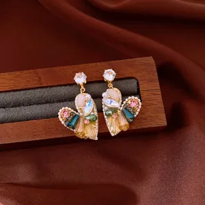 Detailed view of vintage heart-shaped drop earrings with colorful crystal embellishments
