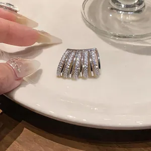 Dettaglio ravvicinato di un ear cuff multistrato in argento con zirconi scintillanti