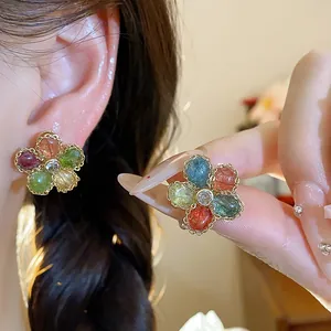 Close-up of vintage flower earrings with colorful zircon stones on gold-plated base