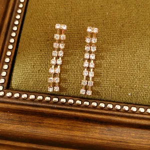 Detailed view of elegant double-row rhinestone tassel earrings set on a vintage background.