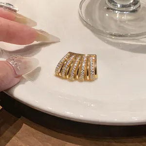 Primo piano di un lussuoso ear cuff multistrato in oro con zirconi cubici