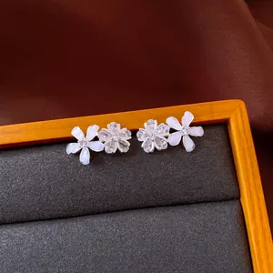 Close-up of elegant double flower stud earrings with resin petals and sparkling zircon stones.
