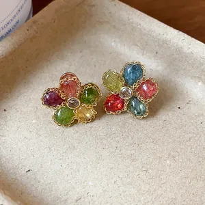 Detailed macro view of vintage flower stud earrings featuring colorful zircon petals