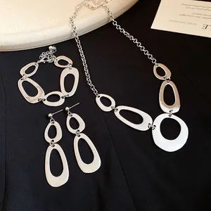 Detailed view of irregular silver geometric necklace, bracelet, and earrings jewelry set