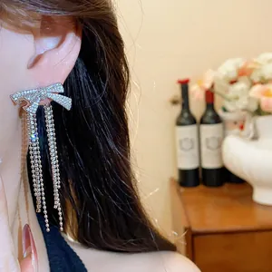 Detail of zircon bow stud earrings with sparkling tassel fringe