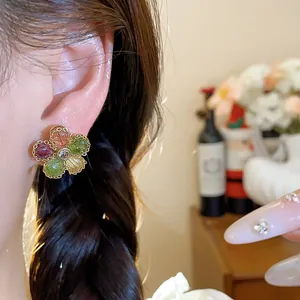 Close-up of vintage multi-colored zircon flower stud earrings worn by an Asian model.