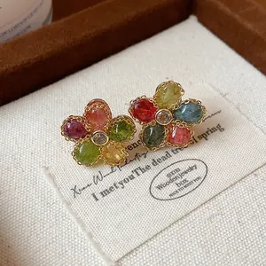 Detailed view of vintage-inspired colorful zircon flower stud earrings with a gold finish