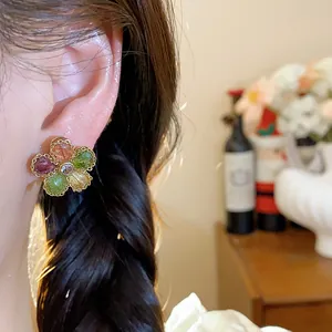 Detailed view of vintage flower earrings featuring vibrant zircon stones and golden metal trim