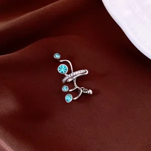 Primo piano di un ear cuff argento multistrato con zirconi turchesi e pietre brillanti