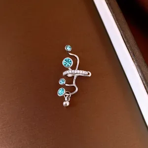 Primo piano di un elegante ear cuff in argento con zirconi blu e micro pavé