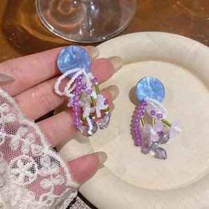 Handmade bohemian beaded drop earrings with blue marble disc and purple crystals
