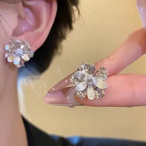 Eleganti orecchini a lobo a forma di fiore testurizzato con cristallo scintillante.