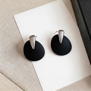 Minimalist teardrop design stud earrings featuring elegant matte black round pendants