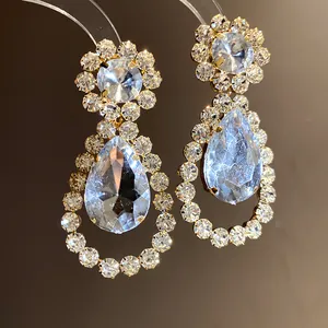 Detailed macro shot of elegant water drop earrings with sparkling crystal rhinestones.