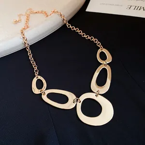 Detail view of a chunky gold-tone necklace with irregular geometric oval pendants.