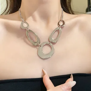 Detailed macro view of a vintage silver irregular oval link statement necklace on a model