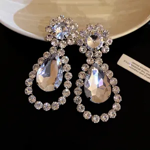 Close-up of elegant rhinestone teardrop earrings with sparkling faceted crystal detail.