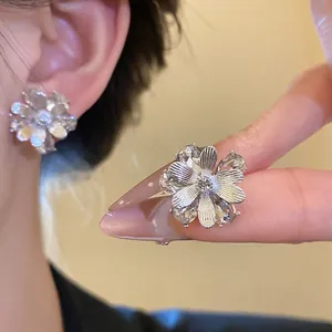 Primo piano di eleganti orecchini a lobo a fiore in argento con petali di cristallo zircone