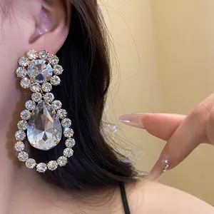 Detailed view of luxury silver needle teardrop drop earrings with sparkling rhinestones