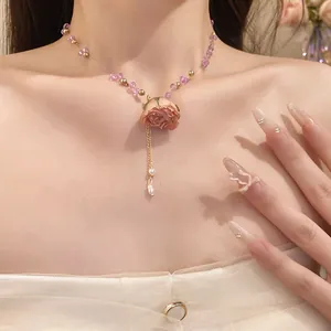 Detailed shot of a sweet beaded clavicle chain with a preserved pink rose pendant