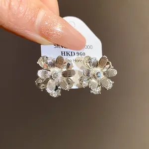 Dettaglio ravvicinato di eleganti orecchini a lobo a fiore con finitura in argento