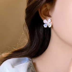 Detail shot of elegant silver floral earrings with colorful petals and pearl center.