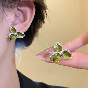 Dettaglio ravvicinato degli orecchini a fiore verde oliva Mori dal design delicato