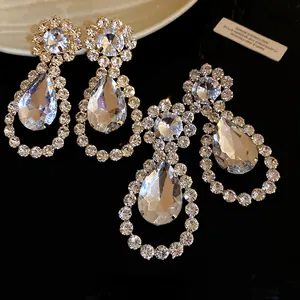 Detailed macro shot of sparkling rhinestone waterdrop pendant earrings on dark background