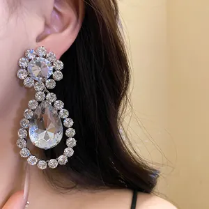 Elegant silver needle crystal teardrop dangle earrings shown as a close-up on model's ear
