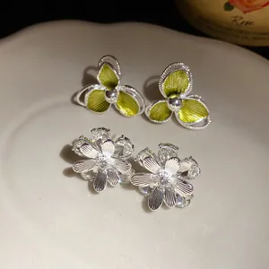Dettaglio orecchini a fiore in argento con cristalli e petali in smalto verde lime.