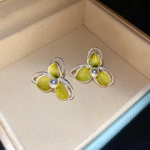 Dettaglio ravvicinato di eleganti orecchini a fiore verde in una scatola di gioielli