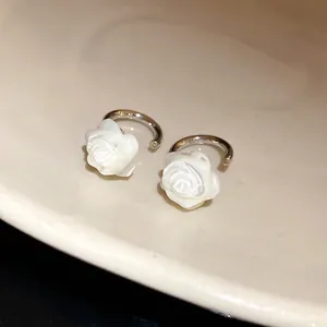 Close-up detail of 18k gold plated earrings featuring exquisite mother-of-pearl roses