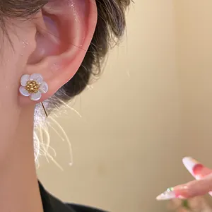 Close-up of elegant 18k gold plated shell flower ear hook earring worn on a model's ear