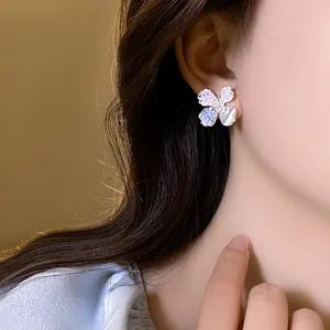 Close-up detail of elegant silver flower earrings with pearls on a model's ear