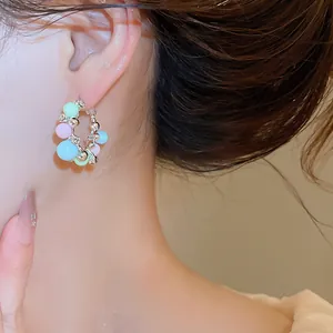Vue détaillée de créoles à perles pastel et zircone sur l'oreille d'un mannequin