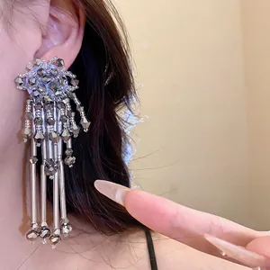 Boucles d'oreilles bohèmes à franges avec fleurs en cristal sur le mannequin.
