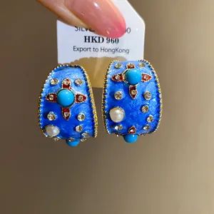 Orecchini a cerchio blu smaltati a forma di C con perle e strass in dettaglio