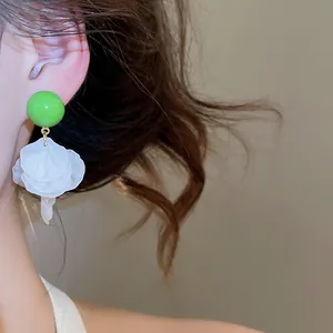 Gros plan de boucles d'oreilles à pampilles en nacre verte pour style de vacances