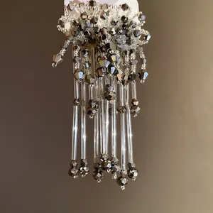Détails de boucles d'oreilles bohèmes à pompons avec perles de cristal gris facettées.