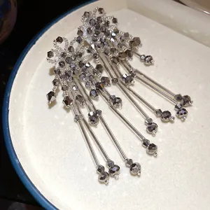 Vue détaillée des boucles d'oreilles bohèmes en cristal avec de longs glands et perles grises