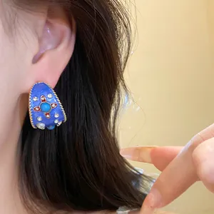 Vista ravvicinata di orecchini a cerchio a C in smalto blu vintage con strass