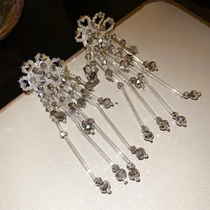Vue détaillée des boucles d'oreilles bohèmes en fleur de cristal à longs pompons