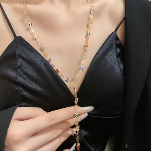 Detalle de un collar en Y dorado con vibrantes mariposas de cristal en varios colores