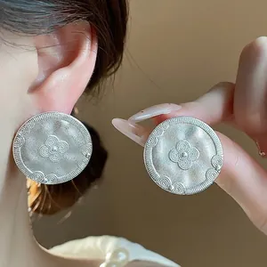 Vintage matte silver round stud earrings with intricate engraved floral pattern design
