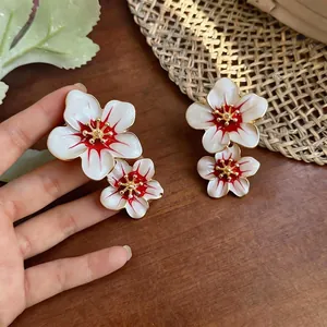 Sweet style white enamel flower stud earrings with red accents and gold finish