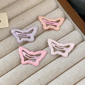 Detailed view of four sweet pastel butterfly drip oil hair clips in a jewelry tray